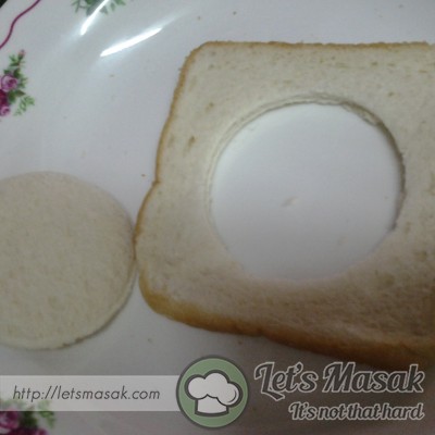 Tekapkan roti yang tidak disapu mentega dgn cawan plastik(buatkan lubang)