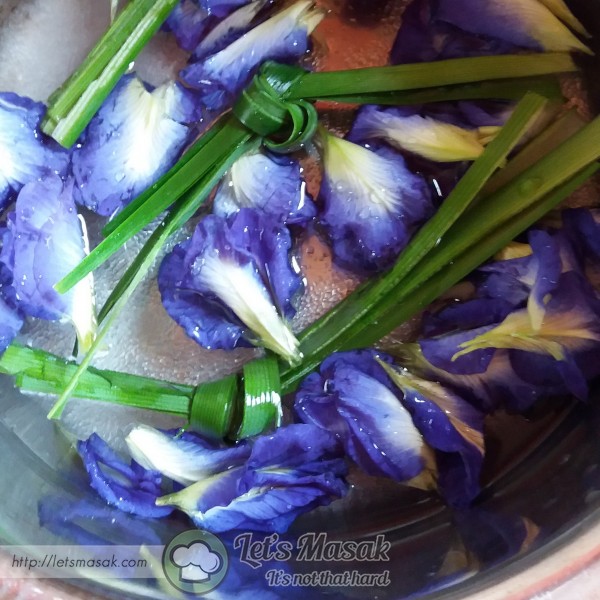 Buang tangkai hijau bunga telang & basuh kelopaknya. Masukkan dalam periuk bersama daun pandan, gula & air.