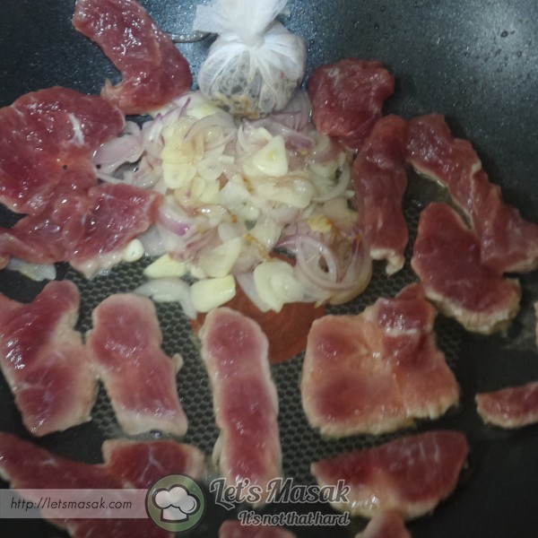 Letakkan hirisan daging ke atas kuali sehingga separa masak